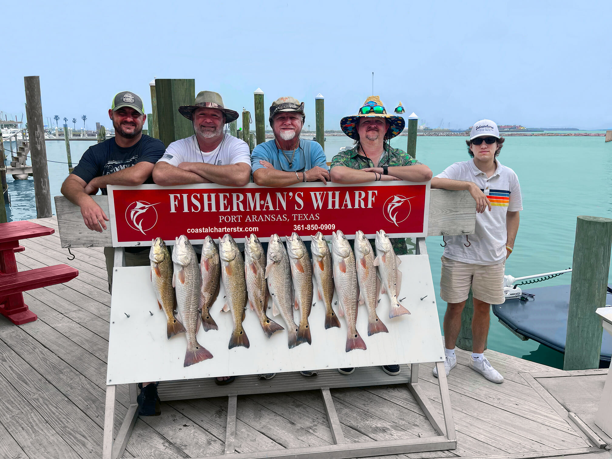 Five fisherman standing behind their fish at Fisherman's Wharf